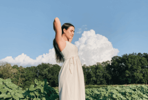 Woman sweating with armpits held up