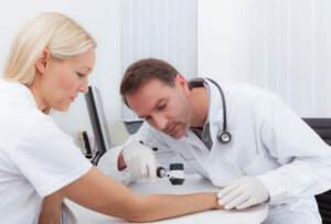 Doctor looking at mole on woman's arm